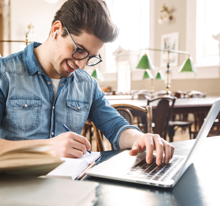 een foto van iemand die achter de laptop studeert